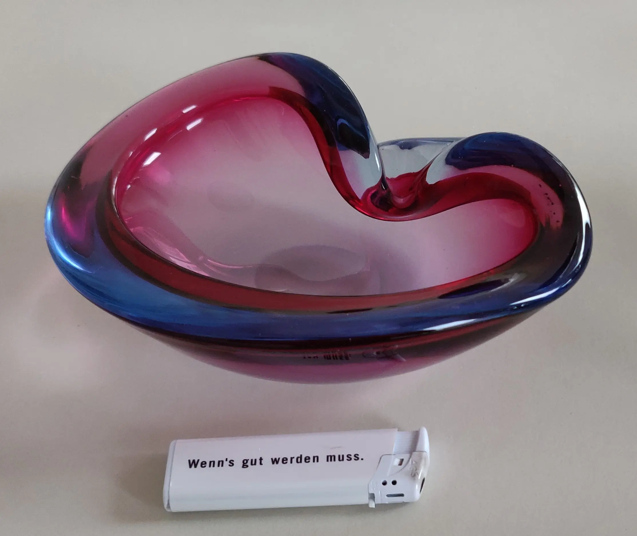 Schwere Murano Glas Schale Aschenbecher rot/blau , Vintage 1950/60er Jahre<br /><br />guter gebrauchter Zustand, keine Chips, keine Abplatzer<br />Klares rot/blaues Glas in Herzform<br />Plangeschliffener Boden mit Schiebespuren<br />kleine Lufteinschlüssse im Glas<br /><br /><br />Länge: 19 cm<br />Höhe: 6,5 cm<br />Breite: 14 cm<br />Gewicht: 1125g